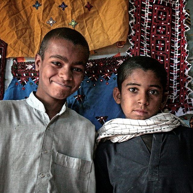 نگاره:  اتاقکی از بلوک‌های سیمانی که در آن پارچه‌ها و لباس‌های بلوچی می‌فروختند و نوجوانان بلوچ به عکس و لبخند مهمانان می‌کردند